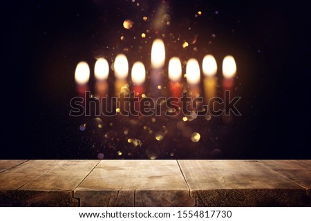 religion image of empty wooden table in front of jewish holiday Hanukkah background with menorah (traditional candelabra). For product display