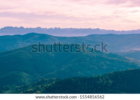 Surreal mountain landscape covered by trees, purple pink mountains and sky, creative inspiration nature concept