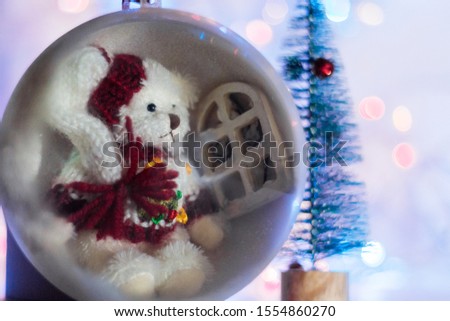 Decorative Christmas ball with Teddy bear inside isolated on colorful background. Festive Christmas background, Christmas and New year spirit.