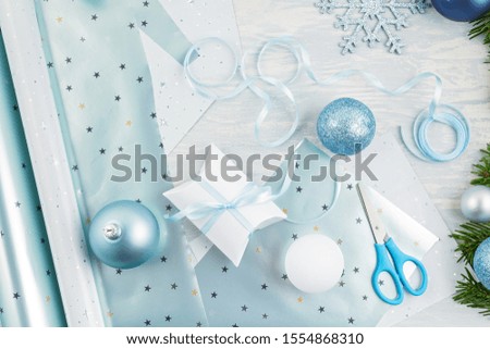 Festive christmas background with blue and silver xmas decoration and gifts over the light wooden background
