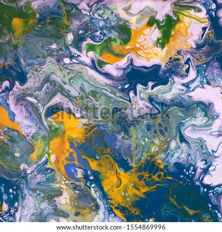 Fluid art abstract background. Paint splash on a canvas. Blue yellow tinted. Multicolor picture. Marble like texture backdrop. Organic random shapes blown with a straw. Acrylic painted pattern.