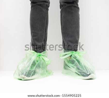 Plastic bag on shoes in the rain. Simple cheap life hack of protection from puddles and dirt on the street