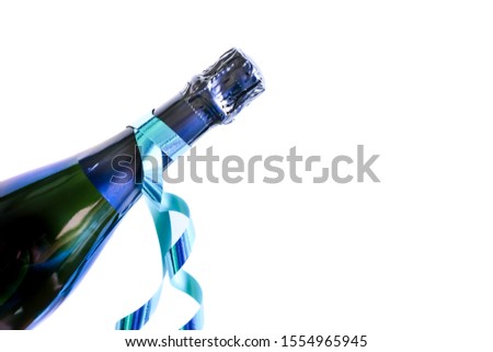 Dark elegant bottle of champagne with blue shiny ribbon on white background. Festive concept. Flat lay style. 