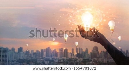Hand holding light bulb and brain and network connection on city background, Idea and imagination, Creative and inspiration. Innovation future and technology.