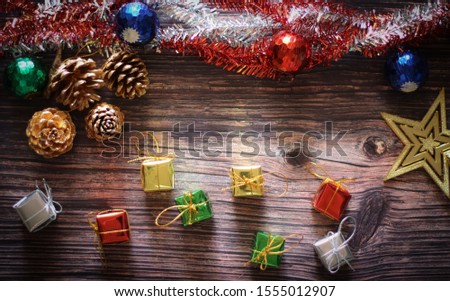 New Year's Christmas background on old wooden floors with pine balls, small gift boxes and Christmas tree decorations.