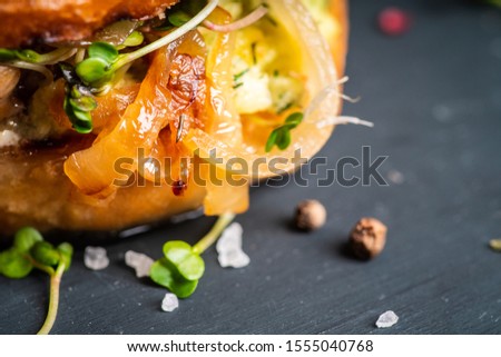 Fresh tasty burgers with roasted chicken, potato, micro greens and different herbs on the rustic background. Selective focus. Shallow depth of field.