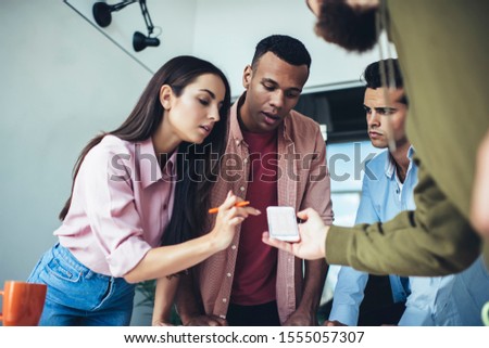 Millennial hipster guys checking notification for cellphone application connected to 4g wireless for browsing internet indoors, male and female bloggers using smartphone device for installing app
