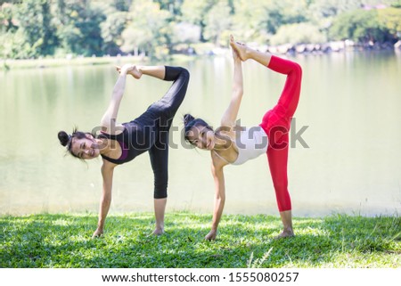 Two Asian women are practicing and doing morning yoga for good health. happily