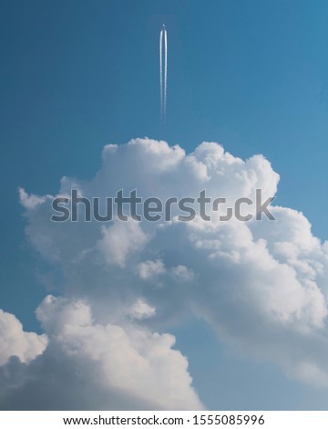 An aeroplane crossing a bunch of clouds. Its conceptual, clouds and aeroplane are two different photos stitched together to make abstract concept.