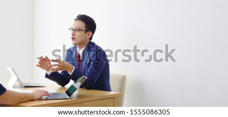 Talking asian businessman in office. Business meeting concept.