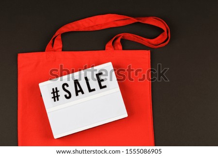eco red natural bag and lightbox with text sale on black background 