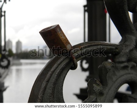 Photo of a background with a metal lock on a metal rusty structure.

