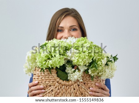 young woman holding hand bag with flowers. isolated studio portrait.