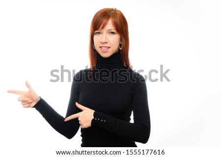 Portrait of a pretty red-haired student girl with long straight hair on a white background in a black jacket. He talks, smiles at the camera, demonstrating emotions, showing with his hands.