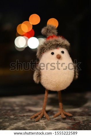 
Toy bird with thin legs in Christmas hat