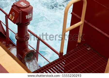 View of ballast water exchange process onboard of a ship using flow-through method underway in open ocean. Overflow method through ballast tank. Ballast Water exchange Management and Treatment concept Royalty-Free Stock Photo #1555230293