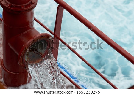 View of ballast water exchange process onboard of a ship using flow-through method underway in open ocean. Overflow method through ballast tank. Ballast Water exchange Management and Treatment concept Royalty-Free Stock Photo #1555230296