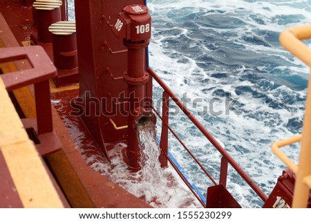 View of ballast water exchange process onboard of a ship using flow-through method underway in open ocean. Overflow method through ballast tank. Ballast Water exchange Management and Treatment concept Royalty-Free Stock Photo #1555230299