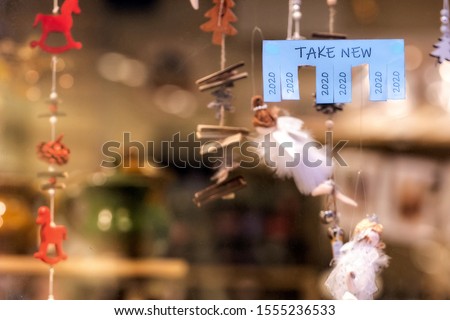 Christmas shop window with paper with the phrase: Take New and with a 2020 sign ready to be tore off - image