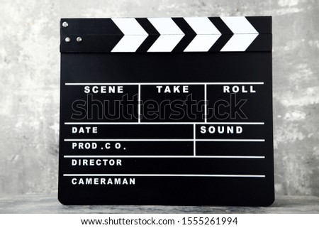 Clapper board on grey wooden table