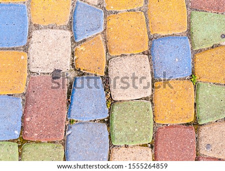 background of multi-colored bricks with which the path is paved