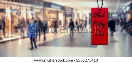 Black friday on a red tag against the background of a shopping mall hyper mall on the day of sales and promotions