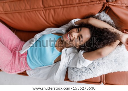 Beautiful young woman resting on sofa and laughing stock photo
