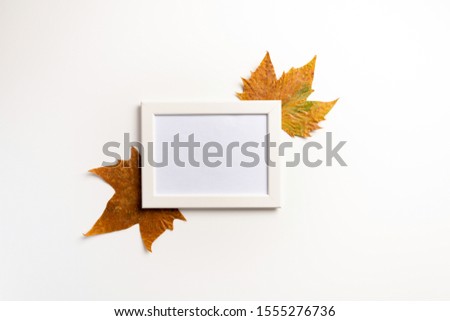 Photo frame, dried leaves on white background. Autumn, fall, concept. Flat lay.