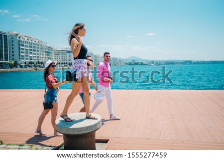 Tourists sightseeing and walking at a modern city boardwalk on a beautiful sunny summer day, thessaloniki