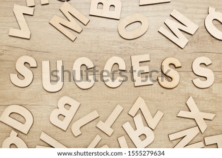 Word success by wooden letters on brown table