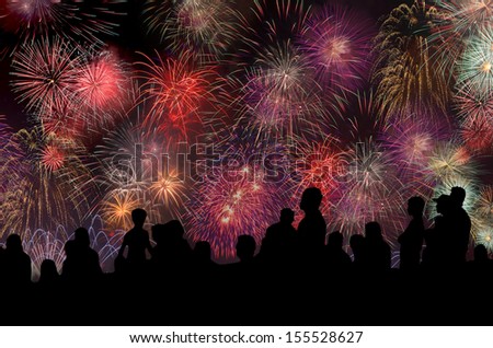 Peoples in silhouette enjoy watching amazing firework show in a festival or holiday 