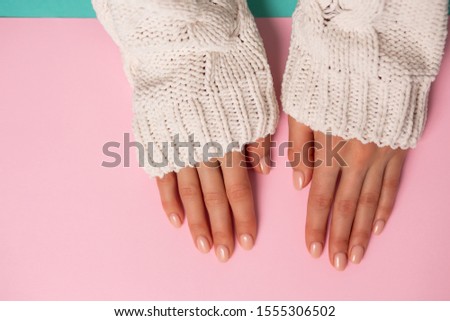 Beautiful woman's hands on pink background