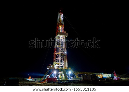 Oil and Gas Drilling Rig. Oil drilling rig operation on the oil platform in oil and gas industry. Beautiful night view of derrick drilling rig in offshore gas field.