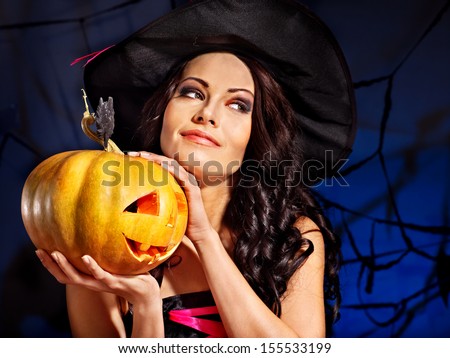 Happy witch holding pumpkin
