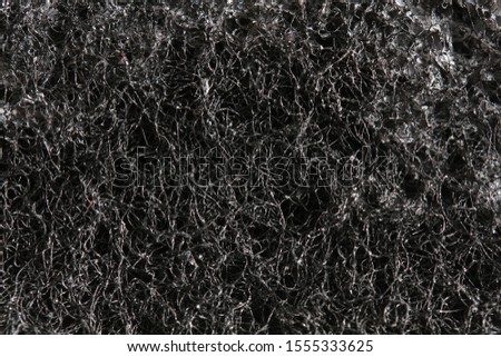 Black sponge for dishes. Sponge for cleaning. Close-up.