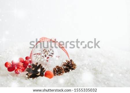 Transparent Christmas ball hanging on red ribbon on snowy winter background Beautiful Christmas bauble decorations lie on the white fluffy snow. Atmosphere of magic and fairy tales