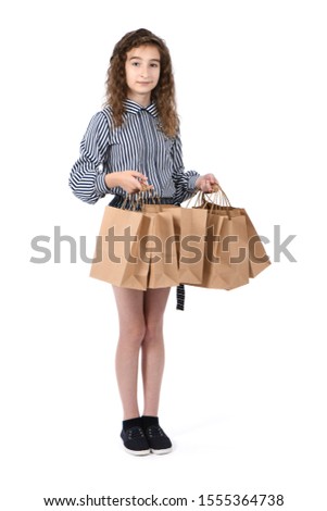 Child with a packet isolated on white background. Kid happy shopping in mall. Happy girl with long curly hair. High resolution photo. Full depth of field.