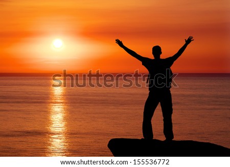 Silhouette of man on top of mountain at sunset. Man on peak of mountain. Conceptual design.