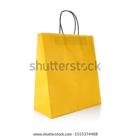 Yellow colour kraft paper gift bag with handle for easy carry. Cut out on white background. Eco & reusable shopping bag for groceries, gifts, goodies. Design template for Mock up, Branding, Advertise Royalty-Free Stock Photo #1555374488