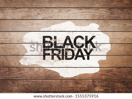 Black Friday sign on white painting and wooden background