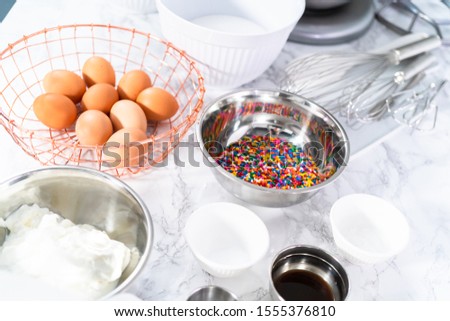 Ingredients to bake funfetti cake with colorful sprinkles.