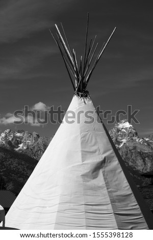 Tipi outdoors with snow capped mountains in the background