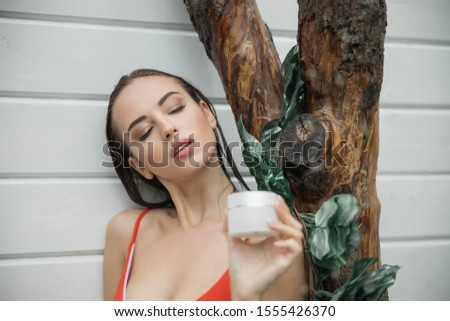 Cute woman in swimsuit standing with cream stock photo