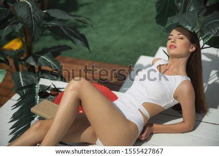 Pretty lady resting with book outdoors stock photo