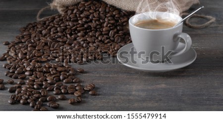 Coffee cup with coffee grains on  wooden table.