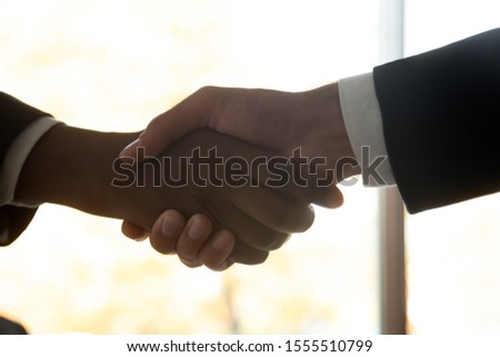 Crop close up of businessmen handshake getting acquainted or greeting in office, male business partners or colleagues shake hands make agreement closing deal after negotiations, employment concept