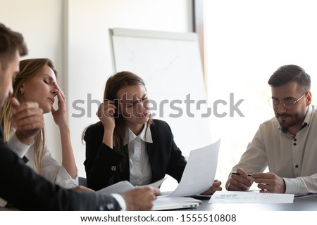 Unhappy diverse colleagues feel stressed losing money experience financial fraud or crisis, frustrated businesspeople distressed with bad work result, paperwork statistics problem or bankruptcy Royalty-Free Stock Photo #1555510808