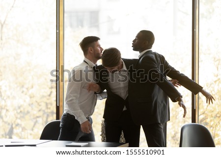 Male employee set apart mad aggressive diverse colleagues fight quarrel in office, angry multiethnic man coworkers have conflict controversy at work meeting, racial discrimination, harassment concept Royalty-Free Stock Photo #1555510901