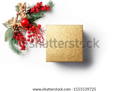 Christmas and new year composition. Creative layout made of gold paper blank on white background. Fir tree branches, red berry and decorations on white background. Winter concept. Flat lay. Copy space
