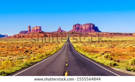 Highway 163 leading to the towering sandstone Buttes and Mesas of the Monument Valley Navajo Tribal Park in Utah-Arizona, United States. 'Forest Gump Point' where he stopped his cross country run Royalty-Free Stock Photo #1555564844